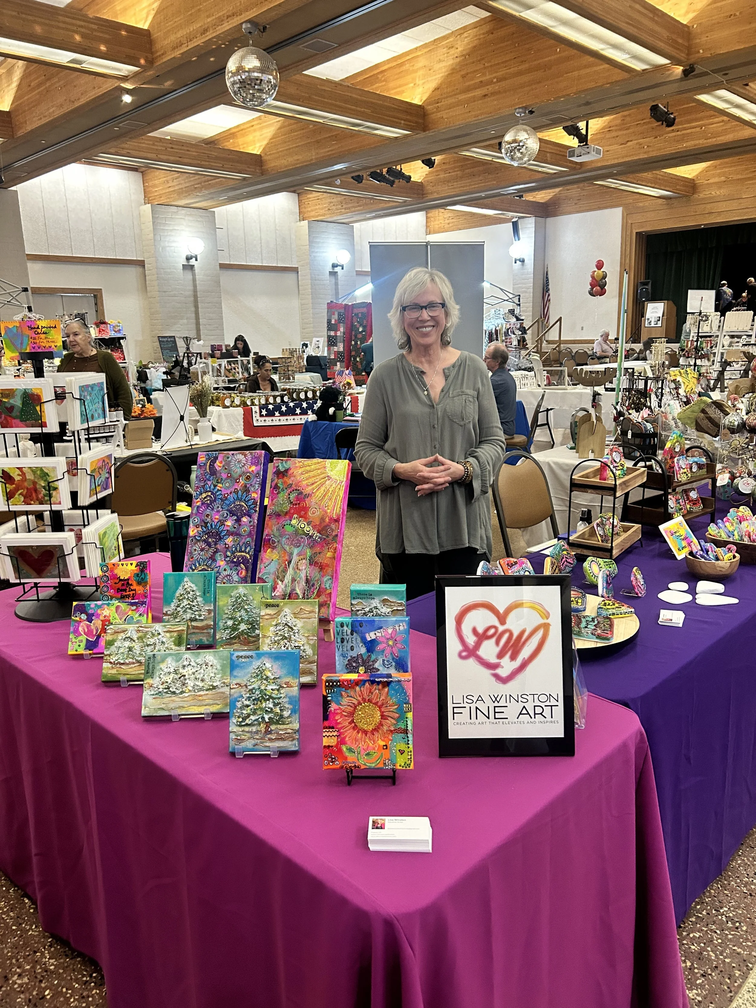 A vendor table set up with glass and pottery art at a past Community Faire